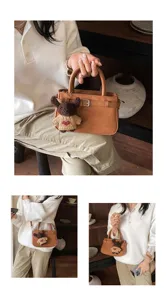 Brown retro brushed top-handle crossbody bag detail, featuring cute bear pendant and fine stitching.