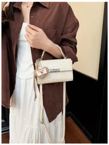 Casual commuter retro square handbag for women, stylish shoulder crossbody bag with cute charm.