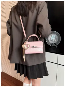 Stylish pink retro small square shoulder bag with top handle and cute cherry heart pendant.