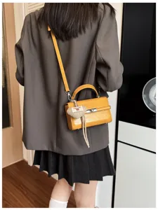 Stylish retro yellow leather shoulder bag with top handle, metal lock and cute heart charm.