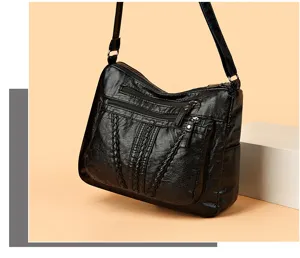 Detail view of black soft leather multi-pocket shoulder crossbody bag with braided front.
