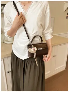 Retro brown crossbody bag with a cute heart charm, perfect for daily casual commuter wear.