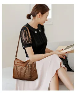 Detail shot of the brown leather shoulder bag featuring multi pockets and braided design.