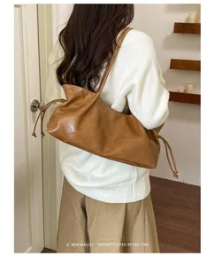 Detailed view of a casual retro slouchy shoulder bag in brown PU leather with drawstring style.
