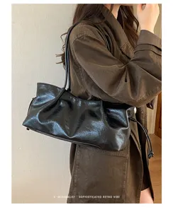 Detail shot of black crinkled leather shoulder bag, retro minimalist style, daily commuting tote.