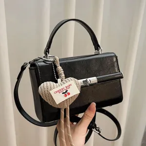 Black vintage small square handbag for women with chic knitted heart charm and metal lock.