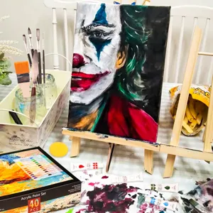 Vista dettagliata del set di colori acrilici con 24 tonalità, pennelli e tela sul tavolo da pittura.