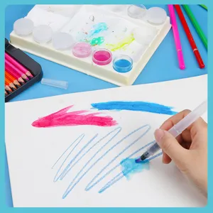 Detailed close-up shot of watercolor pencil painting set with palette and water brush in action.
