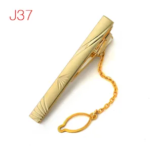 Gold metal tie clip with chain and geometric pattern, elegant men's formal suit accessory.