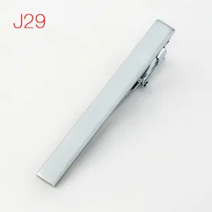 Close-up detail of the minimalist silver metal tie clip showing refined brushed metallic texture.