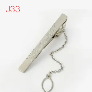 Close-up detail of silver metal tie clip with chain and geometric pattern for men suit.