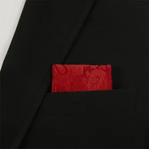 Close-up view of red paisley pocket square detail inside black suit jacket pocket.