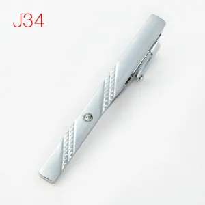 Detail view of a men's metal tie clip featuring geometric texture and a sparkling rhinestone.