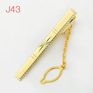 Gold metal tie clip with chain and geometric jacquard pattern, fine fashion suit accessory.