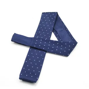 Men's classic navy blue knitted flat-end tie with white polka dot pattern for formal wear.