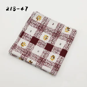 Gedetailleerde opname van het heren pochet met rood-wit ruitpatroon en gele bloemen.