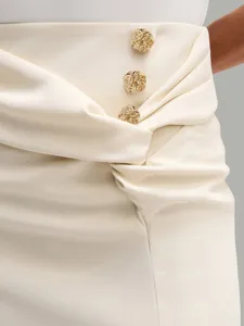 Elegant midi skirt detail featuring stylish waist draping and ornate gold-tone buttons.