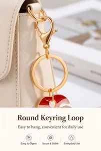 Detailed close-up view of the polished metal round key ring and colorful enameled leaf charm.
