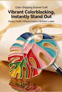 Detailed view of colorful enamel monstera leaf keychain, glossy finish boho metal keyring.