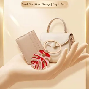 Bohemian style colorful oil drip monstera leaf keychain with mini handbag and cardholder display.