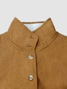 Close-up detail van de kraag van een bruine ribfluwelen damesgilet met witte fleece voering.