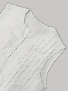 White sleeveless pleated top detail showcasing front slit and refined texture, elegant style.