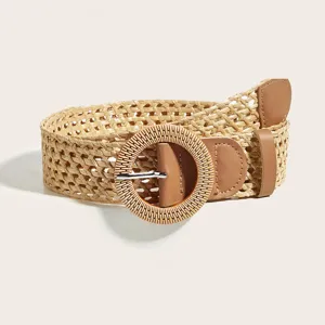 Detail van geweven gevlochten riem met strotextuur en ronde gesp voor damesjurken.