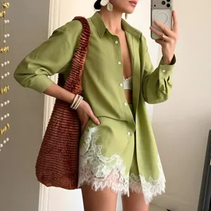 Detail view of avocado green long sleeve shirt and matching shorts with delicate white lace.