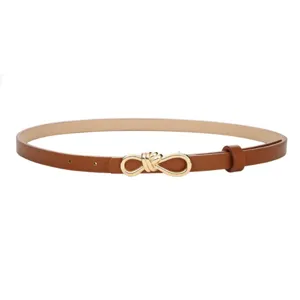 Close-up of stylish brown women's thin leather belt with elegant golden knot buckle design.