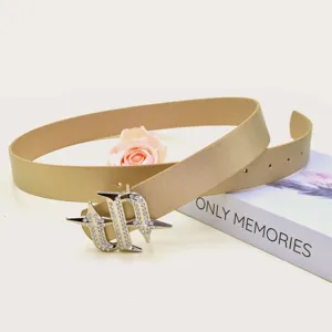 Stylish gold waist belt featuring a stunning rhinestone star buckle for trendy outfits.