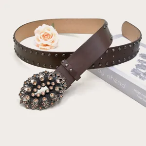 Vintage rhinestone carved buckle brown belt detail, elegant metal studs and fine leather texture.