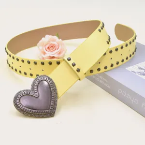 Yellow PU leather belt featuring a vintage metal heart buckle and stylish stud details.