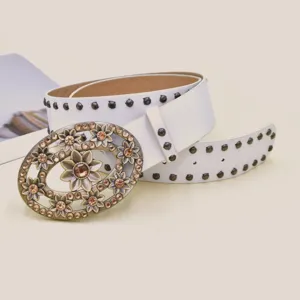 Detailed close-up of a white leather belt with vintage floral rhinestone oval buckle.
