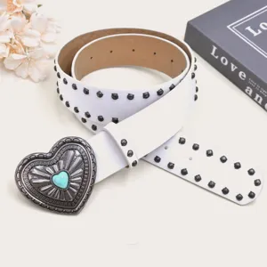 Detailed view of white punk style leather belt with metal studs and vintage heart buckle.
