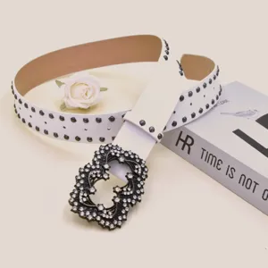 Detailed view of white leather belt with rhinestone buckle and metal studs for women.