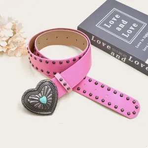 Pink rivet punk leather belt with vintage heart buckle, detailed accessory close up.