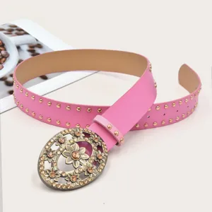 Detailed close-up of the vintage floral rhinestone oval buckle on a stylish pink studded belt.