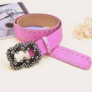 Pink leather belt with metal studs and rhinestone ornate buckle detail shot for women