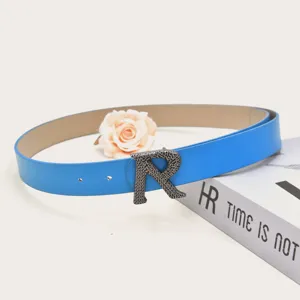 Blue PU leather belt detail showcasing the unique textured metallic R buckle design.