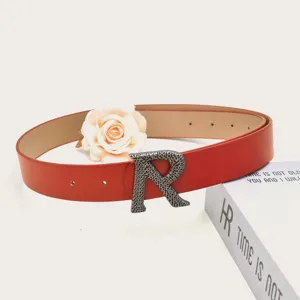 Red PU leather belt featuring a unique metal R buckle, stylish detail view for daily wear.