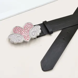 Detailansicht des schwarzen Ledergürtels mit funkelnder Strass-Herz-Flügel-Schnalle, schick.