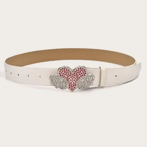 Detailansicht des weißen Ledergürtels mit funkelnder Strass-Herz- und Engelsflügel-Schließe.