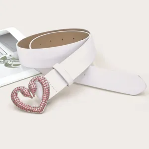 Detailansicht des eleganten weissen Ledergurtels mit funkelndem rosa Strass Herzbuckel.