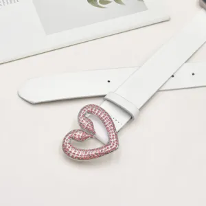 Weißer Ledergürtel mit funkelnder rosafarbener Strass-Herz-Schnalle als Accessoire.