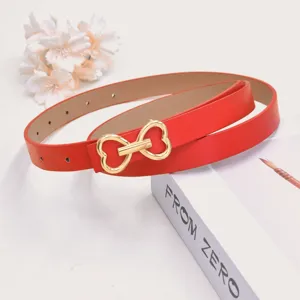Red thin waist belt with cute gold heart buckle, stylish accessory for trousers and jeans.