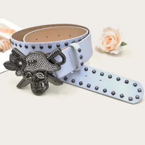 Detailed shot of Y2K rhinestone skull belt with punk rivets and blue leather strap.