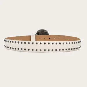 Close-up detail of white leather belt with double row metal studs and textured round buckle.