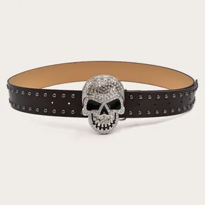 Detailed close-up of a punk style leather belt with a sparkling rhinestone skull buckle and studs.