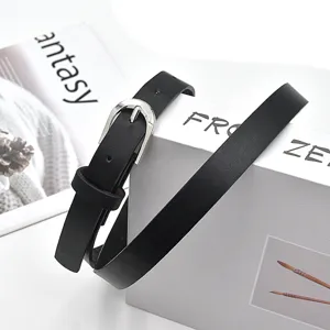 Detailed view of women's black thin belt with metal pin buckle, fashion casual accessory.