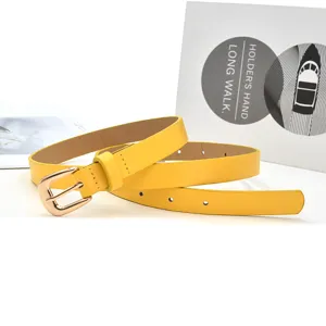 Yellow women thin belt detail view with metallic buckle for dress jeans decoration.
